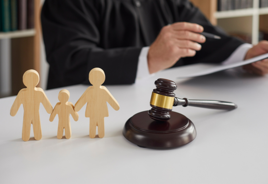 wooden figurine of a family with gavel at the background - concept of family law